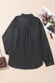Relaxed black denim shirt with buttoned cuffs and a curved hem.