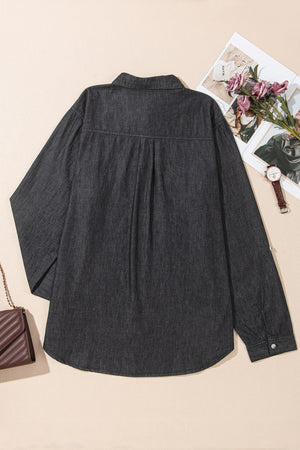 Relaxed black denim shirt with buttoned cuffs and a curved hem.