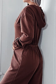Brown hooded lounge jumpsuit with drawstring waist and wide legs.