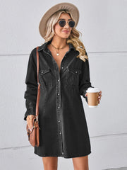 Black oversized denim shirt dress with button front, chest pockets, and cuffed sleeves.