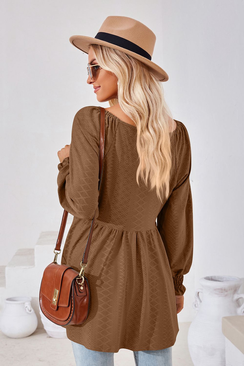 Brown textured babydoll blouse with smocked cuffs and square neckline.