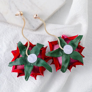 Velvet rose cascade earrings in deep red with green leaves and gold wavy stems.