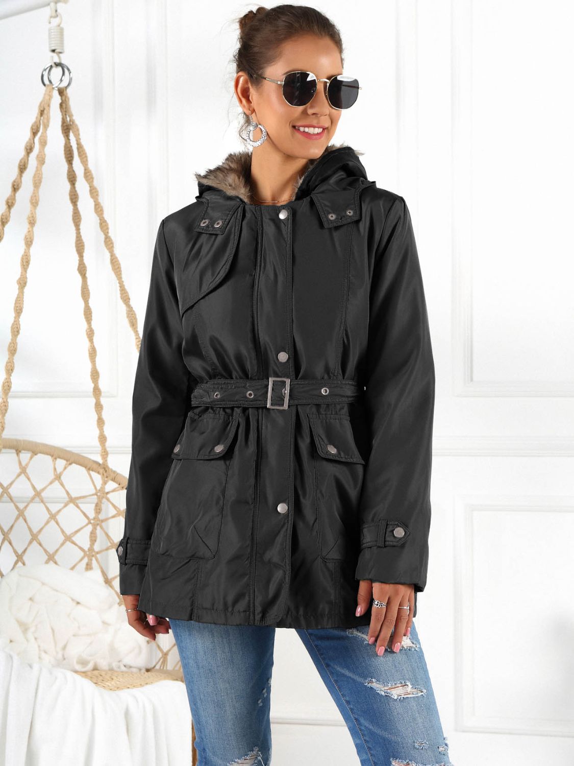 Black belted utility parka with faux fur hood trim and button flap pockets.