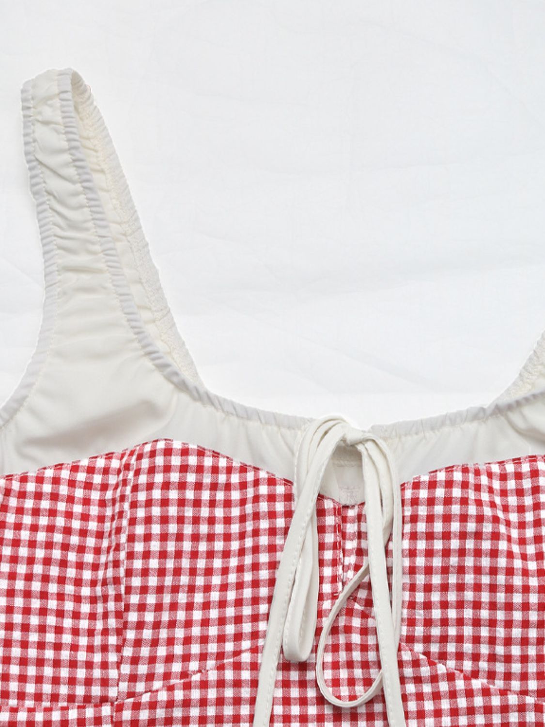 Gingham tie-front bustier top in deep red with white lining and ruched straps.