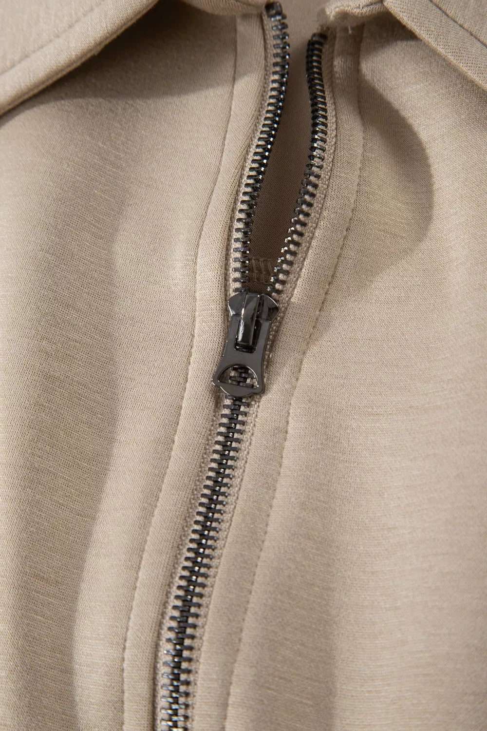 Chic collared zip front romper in beige with cap sleeves and pockets.