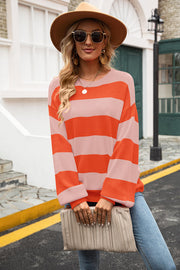 Oversized knit sweater with bold pink and orange stripes, balloon sleeves, and crew neck.