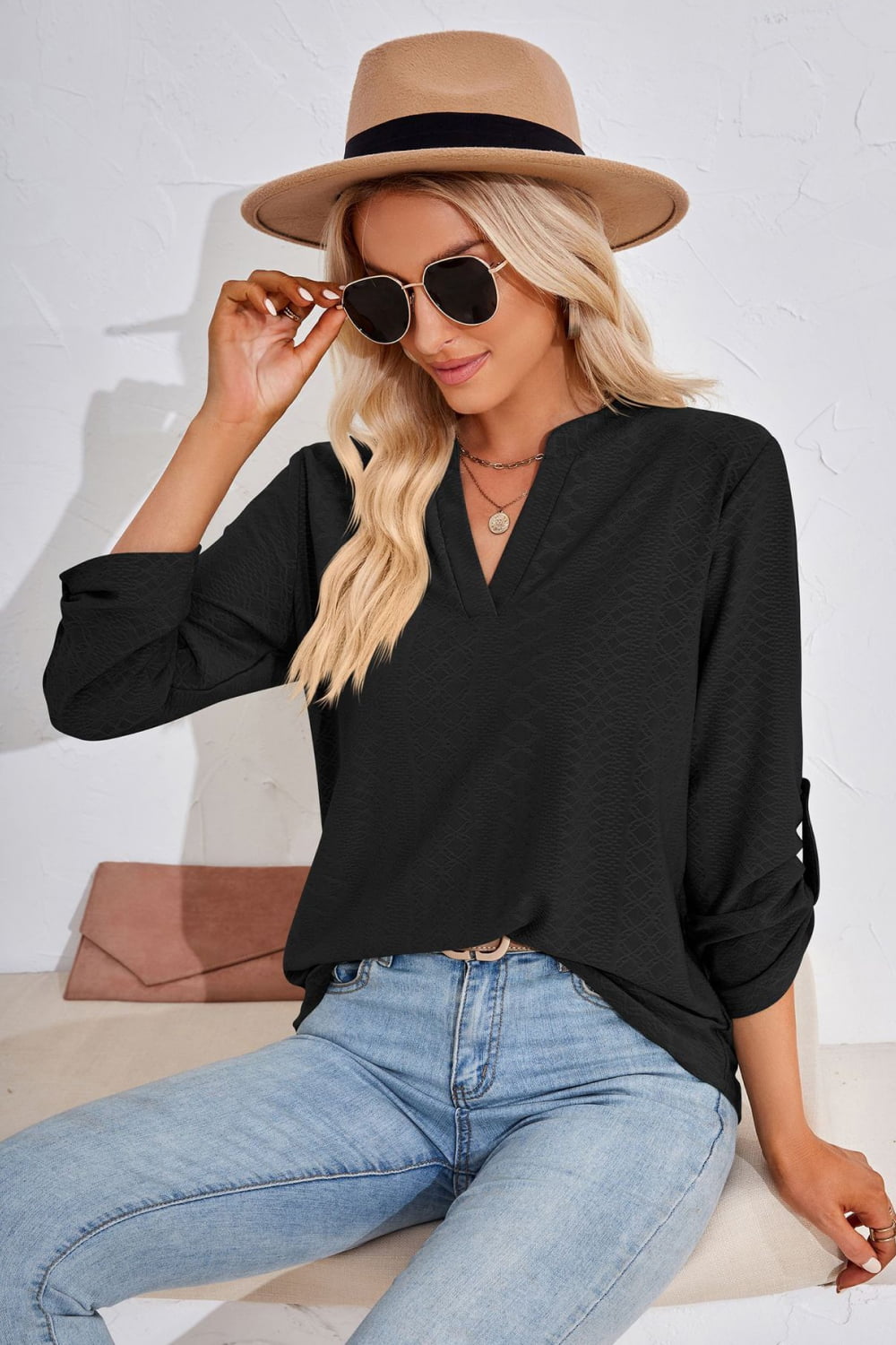 Black textured henley blouse with v-neck and rolled sleeves