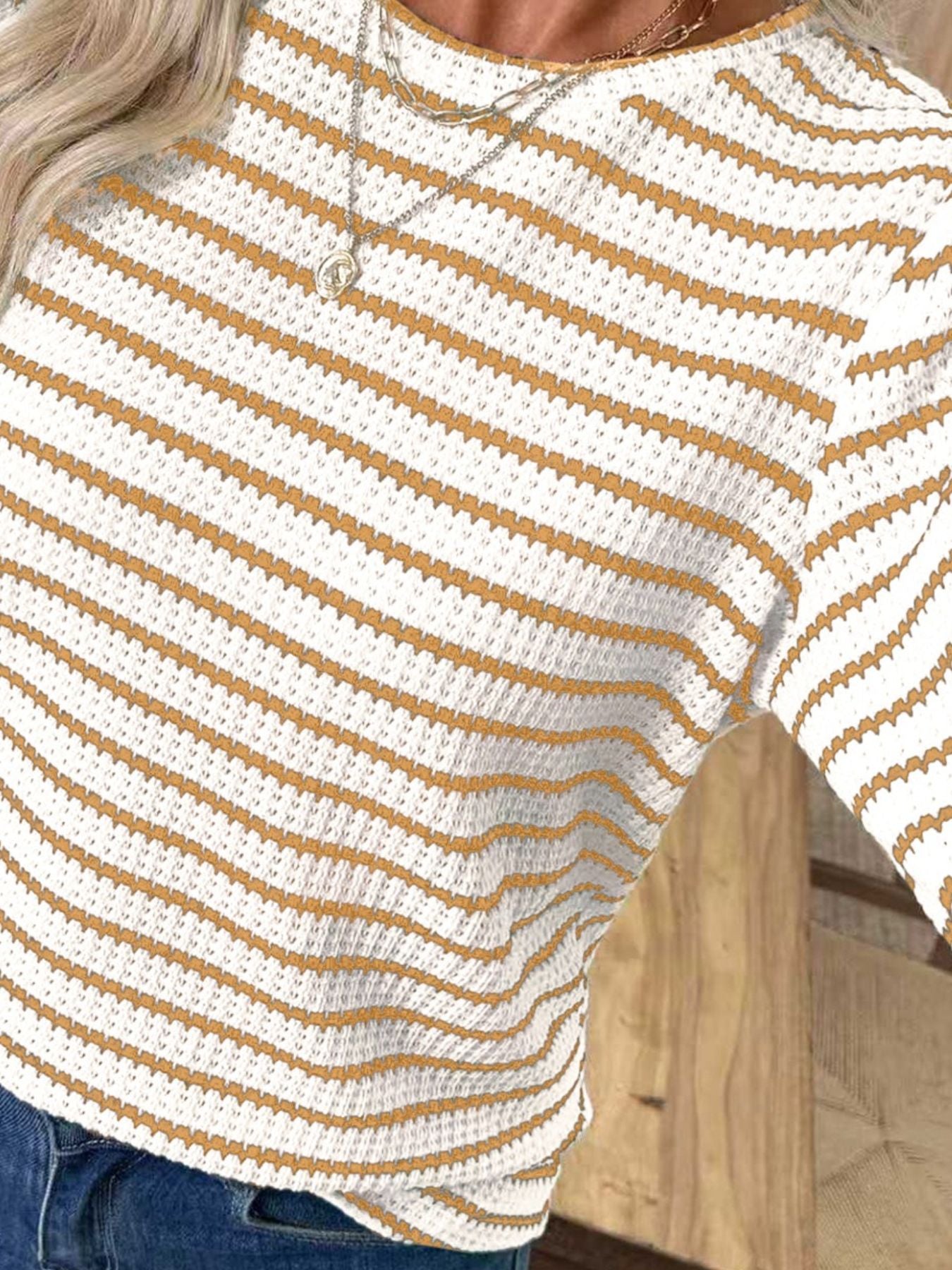 Textured knit long-sleeve t-shirt in white with thin orange stripes.