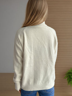 Relaxed raglan turtleneck knit sweater in cream with ribbed cuffs and hem.