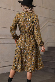 Olive animal print midi dress with gathered waist and long sleeves.