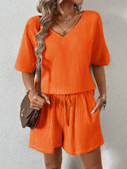 Orange textured gauze lounge set with v-neck top and drawstring shorts.