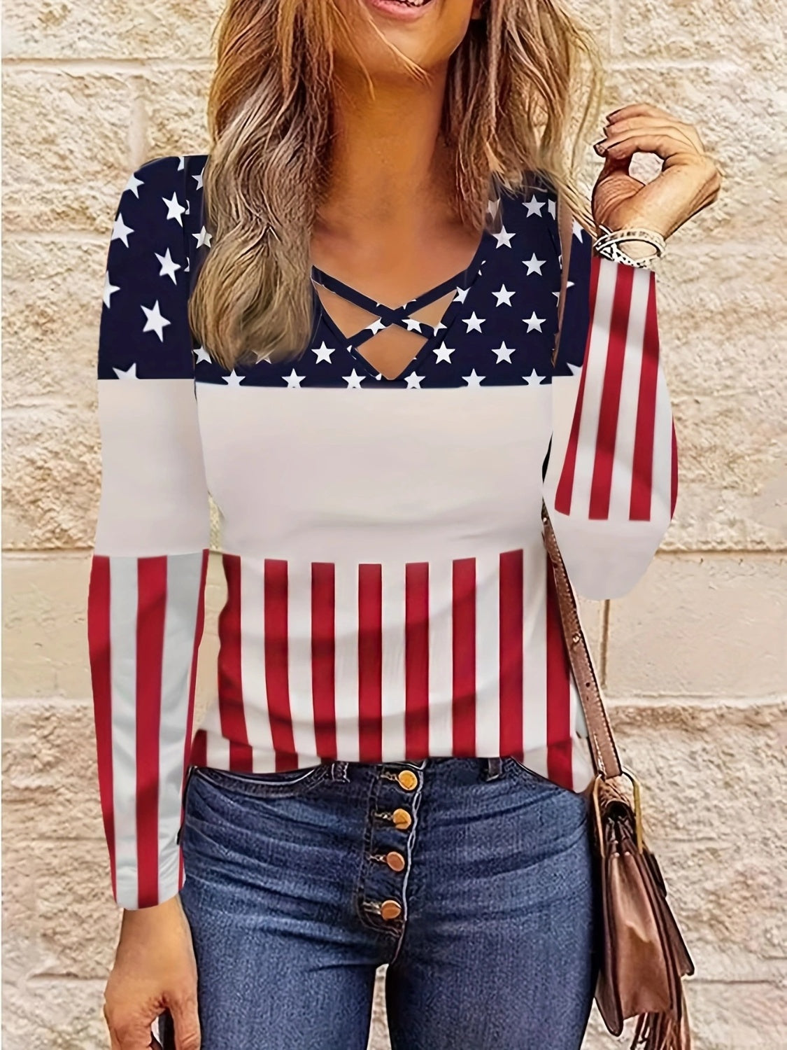 Long sleeve top with crisscross neckline and patriotic stars and stripes print.