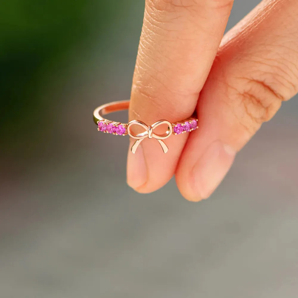 Rose gold ring with a bow and pink gemstones, 18K.