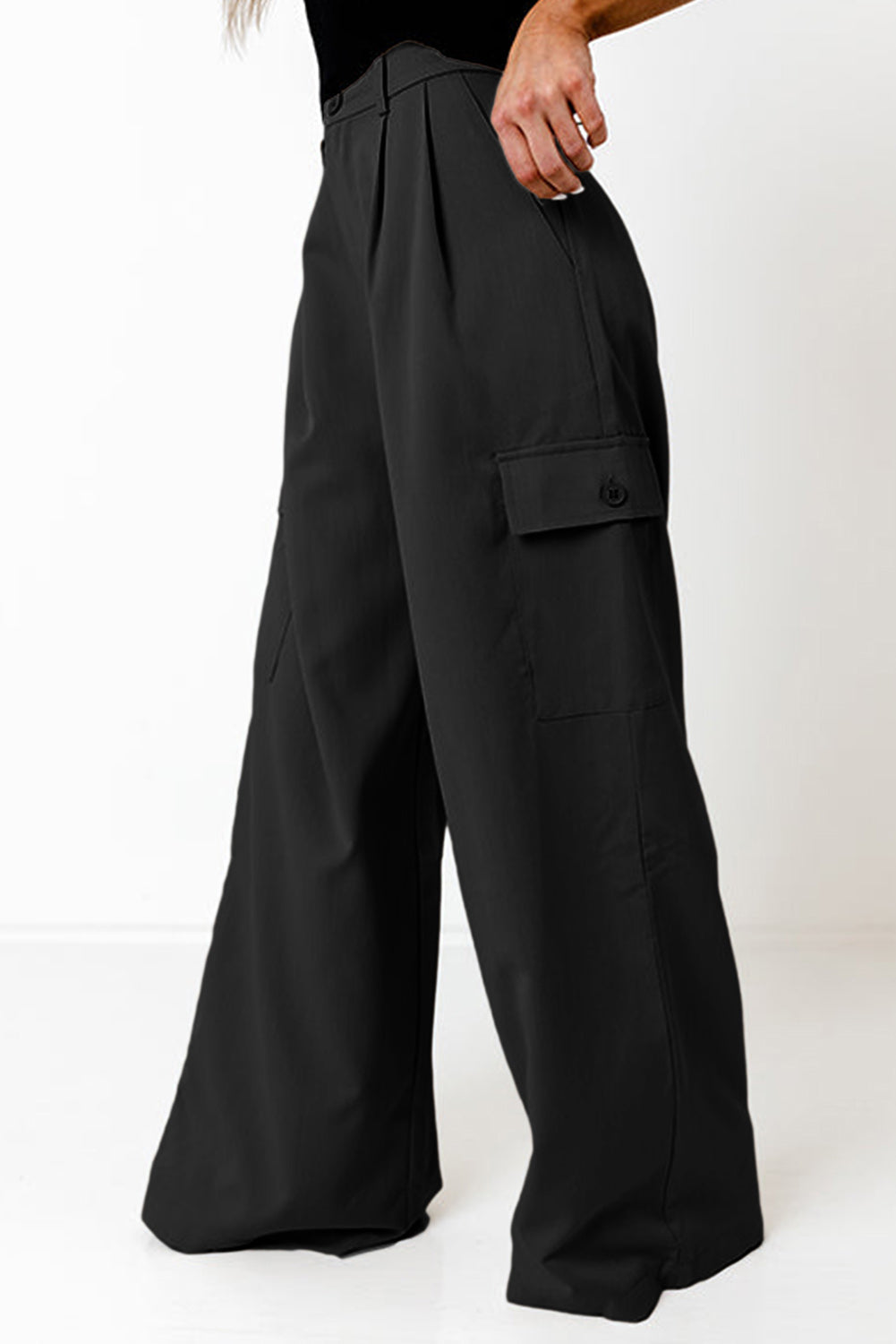 Black wide-leg pleated cargo trousers with button flap pocket detail.