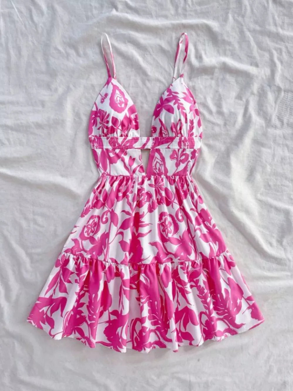Vibrant floral cutout mini dress with tiered ruffle hem and spaghetti straps.