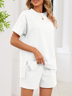 Relaxed white two-piece set with short sleeves, crew neck, and pocketed shorts.