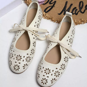 White floral cutout slip-on flats with a tie detail