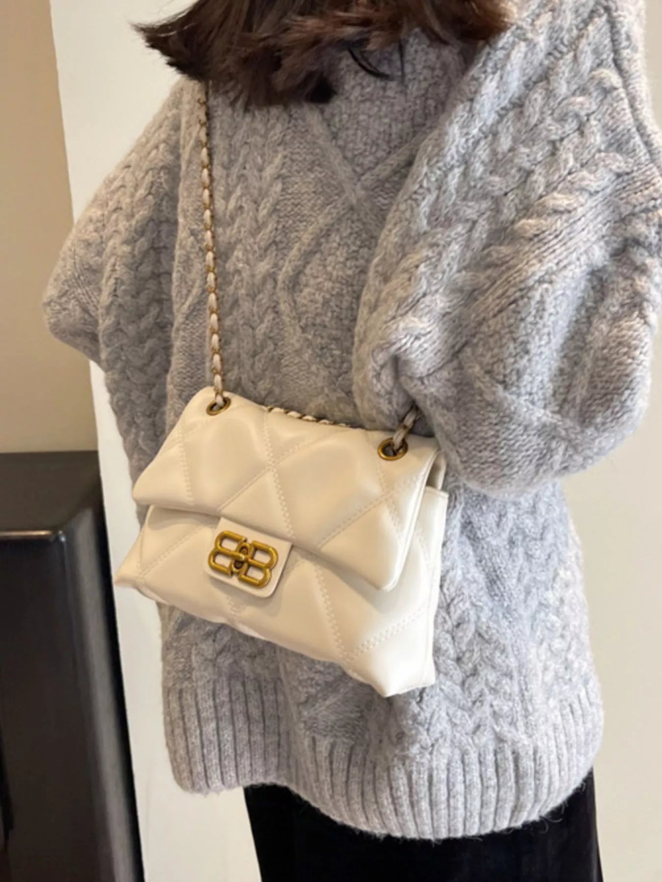 White quilted flap chain shoulder bag with gold hardware and a diamond pattern.