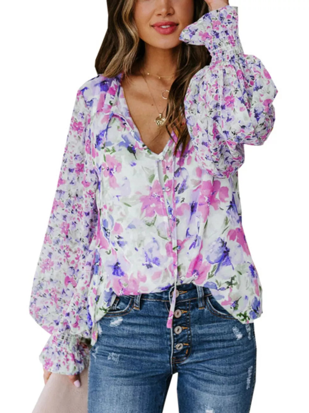 Vibrant floral print blouse with tie detail and smocked cuffs.