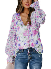 Vibrant floral print blouse with tie detail and smocked cuffs.
