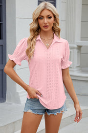 Pink eyelet polo blouse with short puff sleeves and a v-neck.