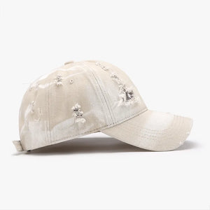 Shredded canvas baseball cap in ivory with distressed details.