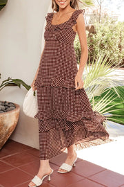 Brown polka dot maxi dress with ruffled neckline and tiered skirt.
