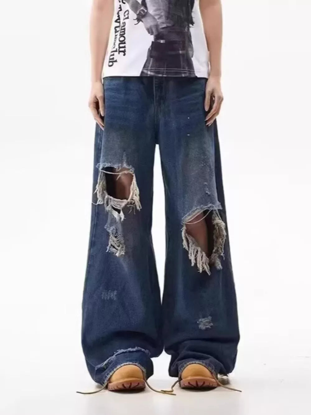 Men's distressed wide-leg jeans in dark wash denim with large rips.