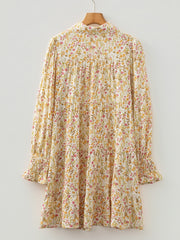 Floral print tiered shirt dress with buttoned collar and smocked cuffs.