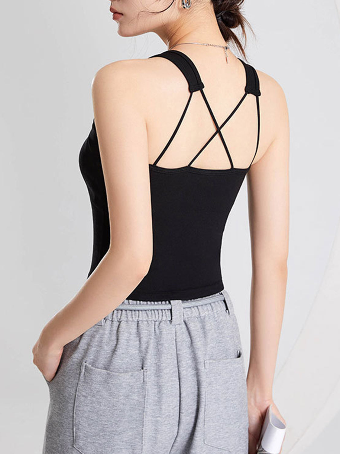 Black crop tank with crisscross spaghetti straps on the back.