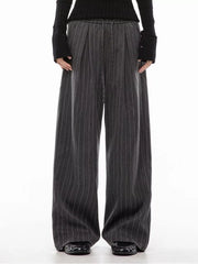 Men's dark grey pinstripe wide-leg pleated trousers with drawstring waist.