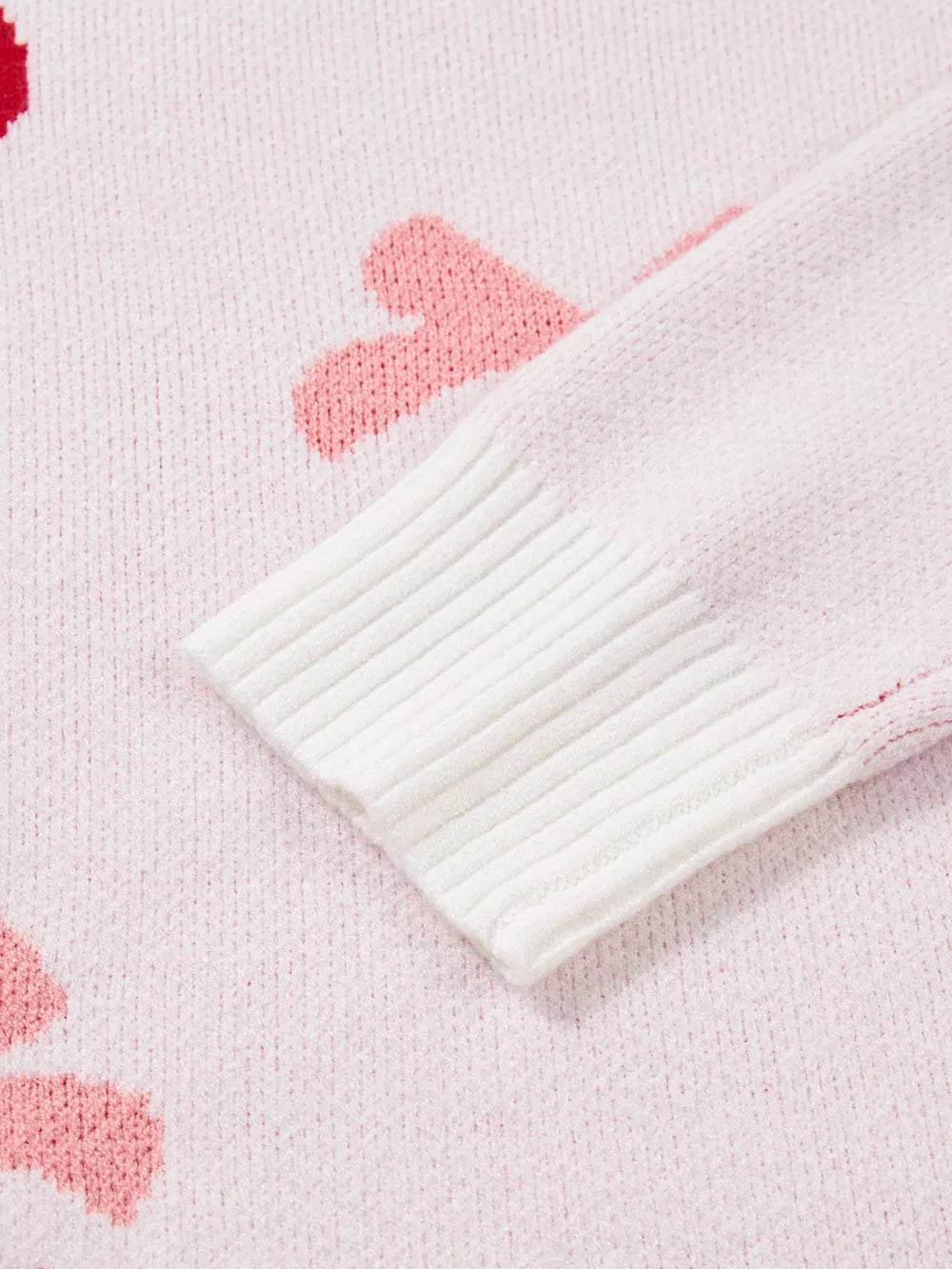 Blush pink knit sweater with cherry appliqué and white ribbed cuffs.