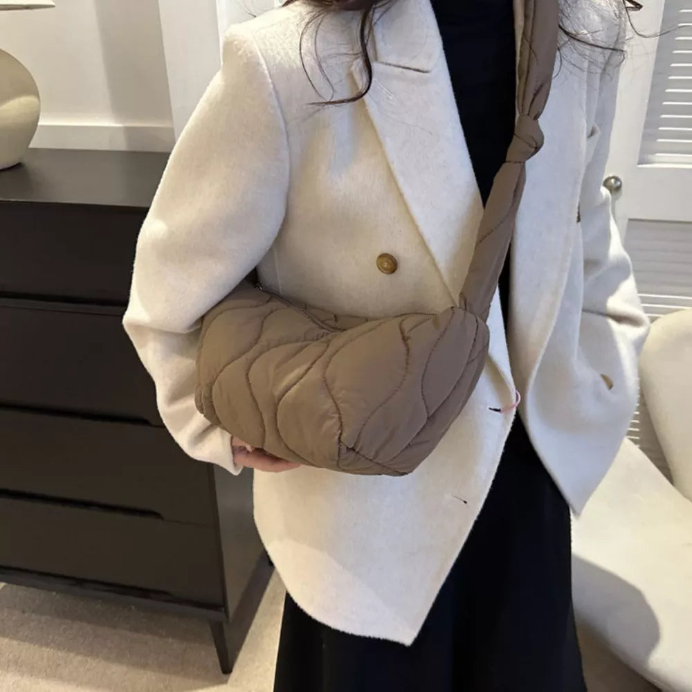 Puffy quilted crossbody bag in brown with knotted strap and abstract pattern.