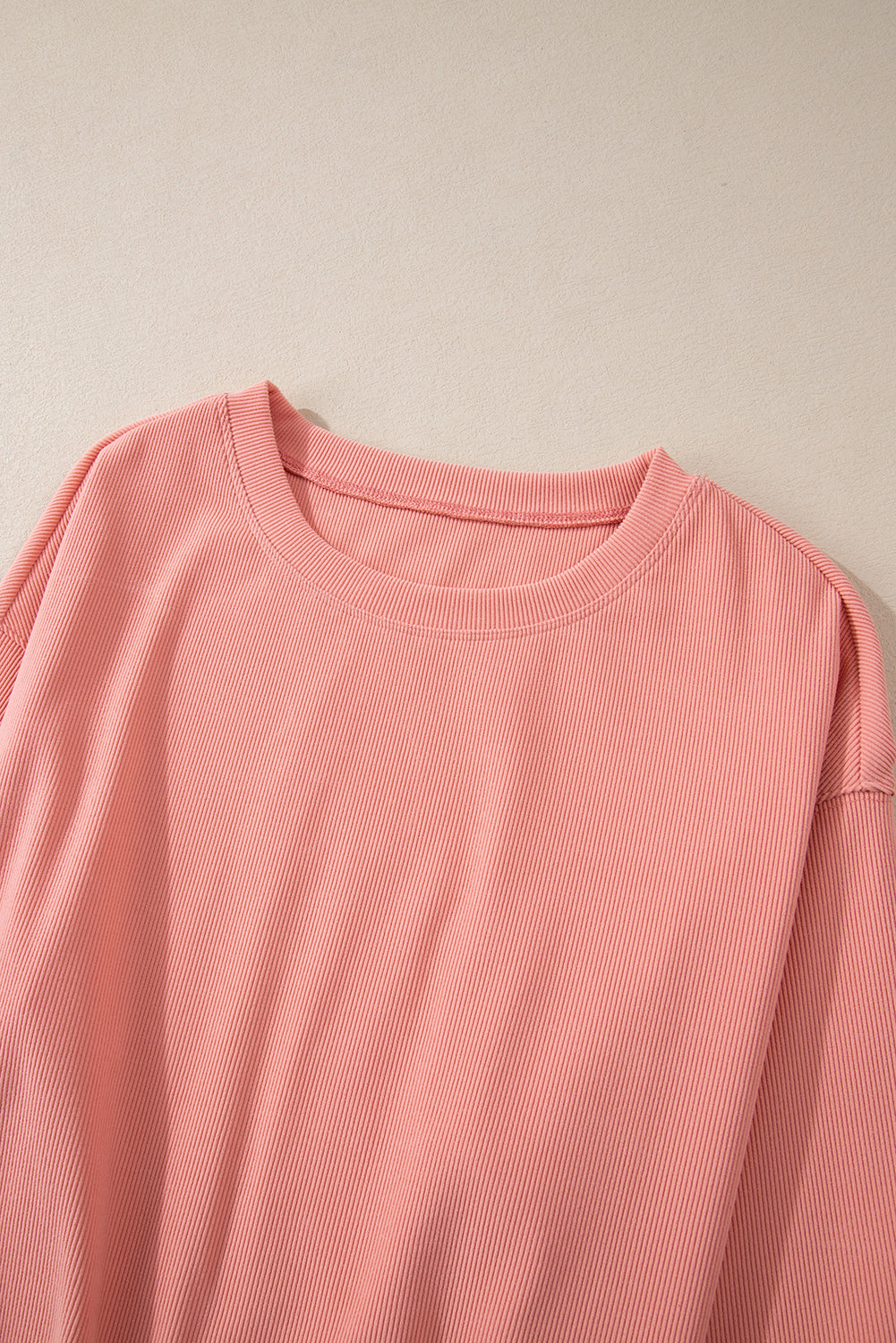 Pink corduroy loungewear set with crewneck top and relaxed fit.