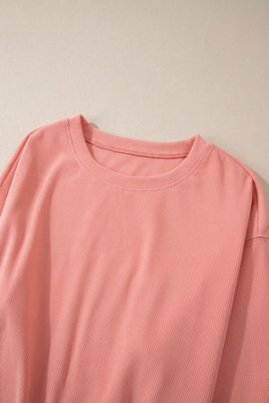Pink corduroy loungewear set with crewneck top and relaxed fit.