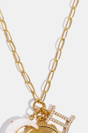 Gold chain pendant necklace with Gemini zodiac sign charm and celestial accents.