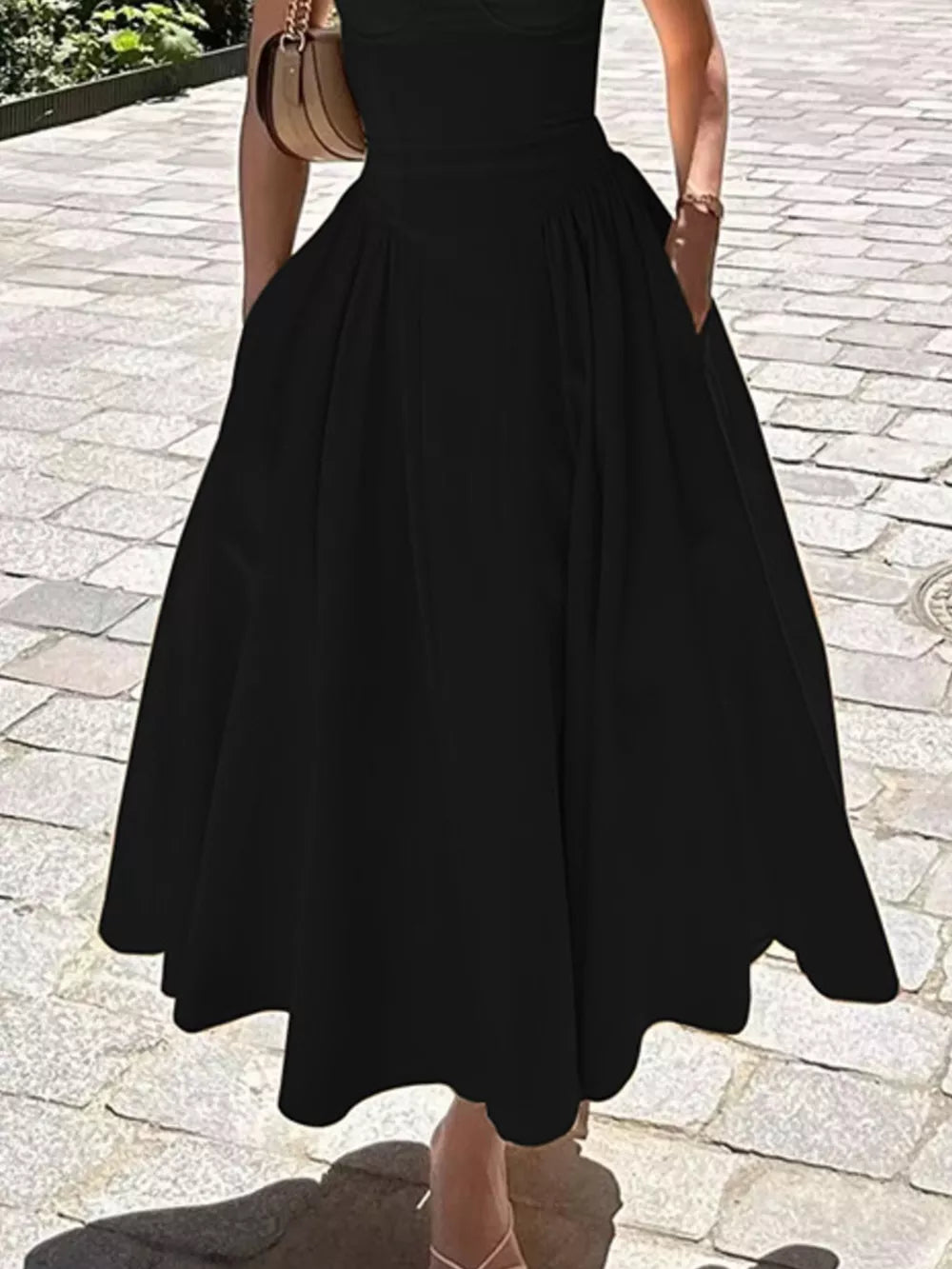 Black midi dress with sweetheart neckline, spaghetti straps, and pockets.