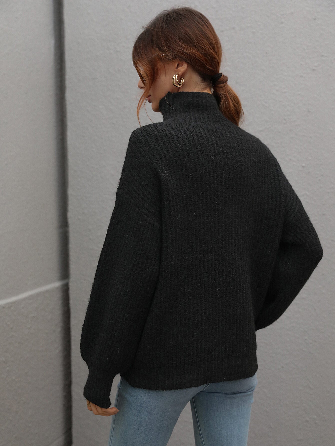 Voluminous turtleneck ribbed knit sweater in black with balloon sleeves.