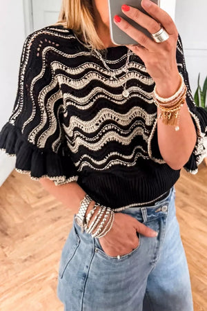 Black openwork knit sweater with metallic wave pattern and ruffled sleeves.