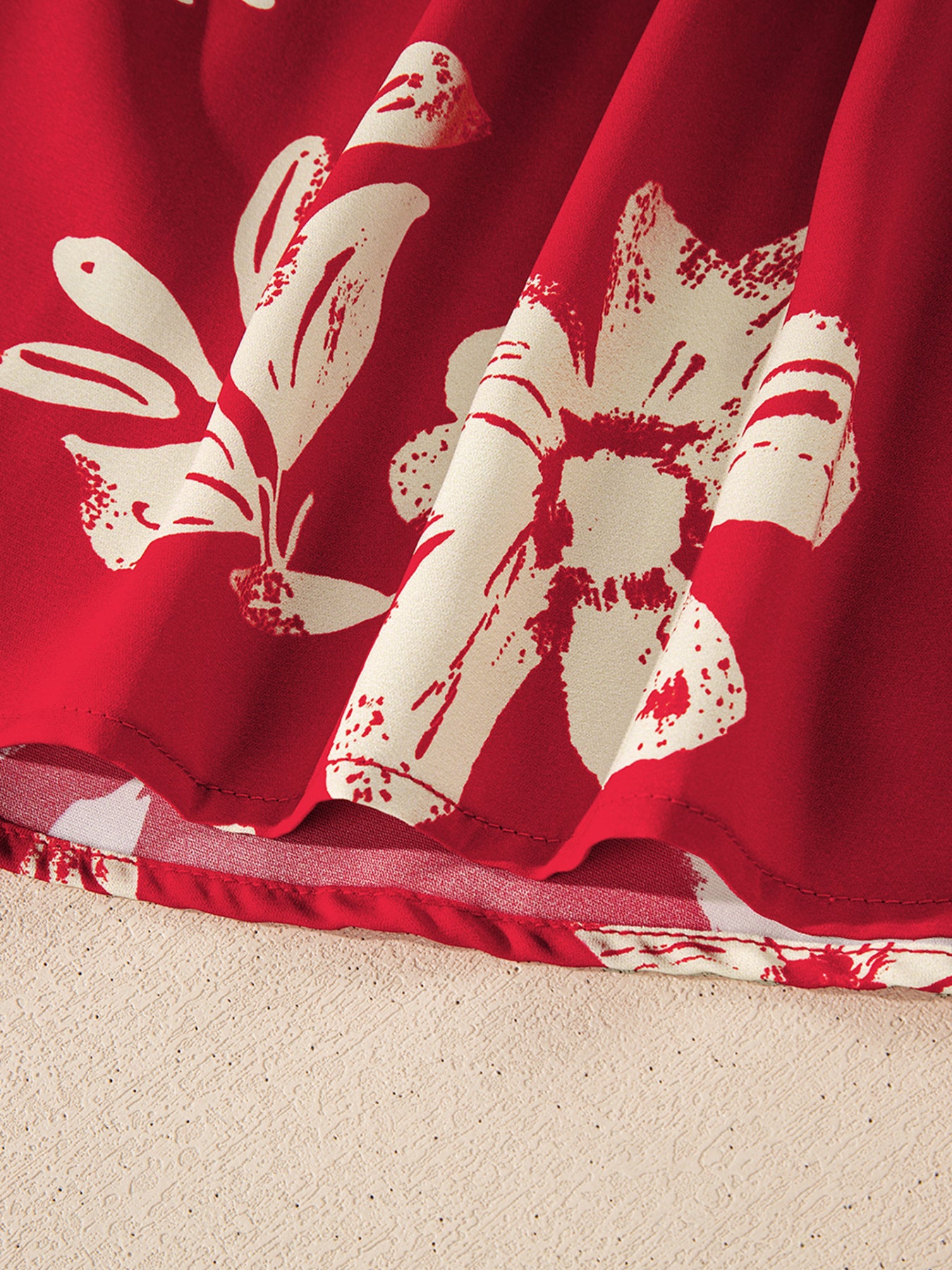 Red floral print blouse with bow tie detail, showing fabric texture and hem.
