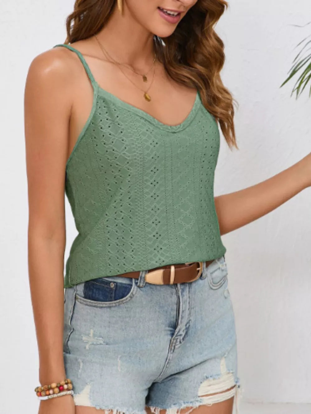 Green eyelet camisole with V-neck and lace trim, styled with denim shorts.