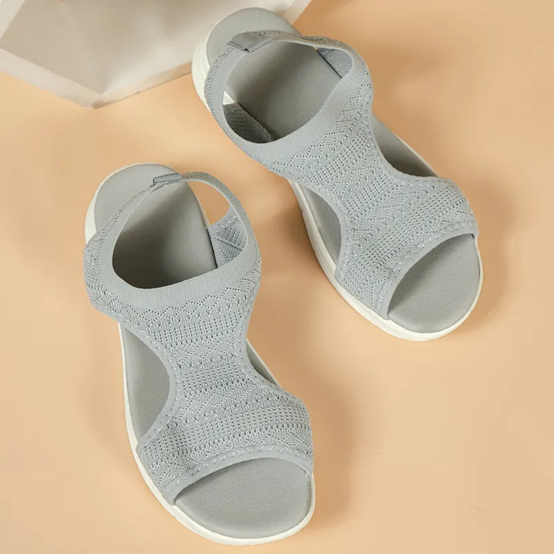 Light gray knit sandals with a peep-toe and block heel.