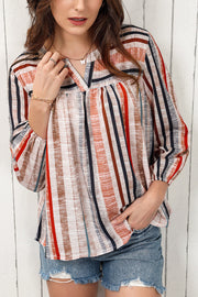 Vertical stripe gathered yoke blouse with V-neck and long sleeves.