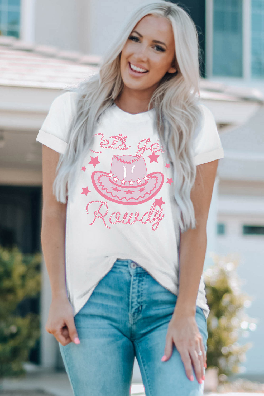 White graphic t-shirt with pink cowboy hat and stars saying "let's go Rowdy