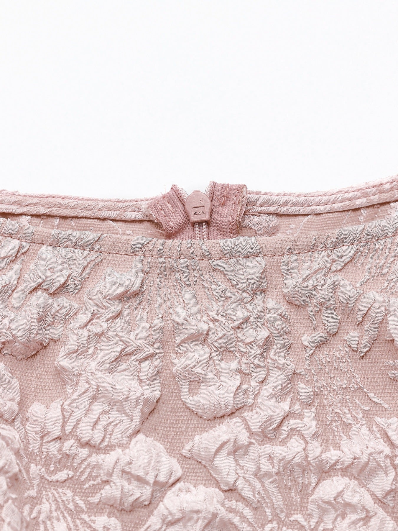 Dusty pink textured floral peplum tank top with a boat neckline and zip closure.