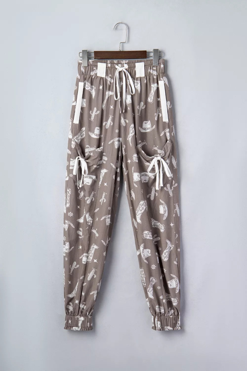 Brown cotton joggers with white western print, drawstring waist, and cuffed ankles.