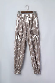 Brown cotton joggers with white western print, drawstring waist, and cuffed ankles.