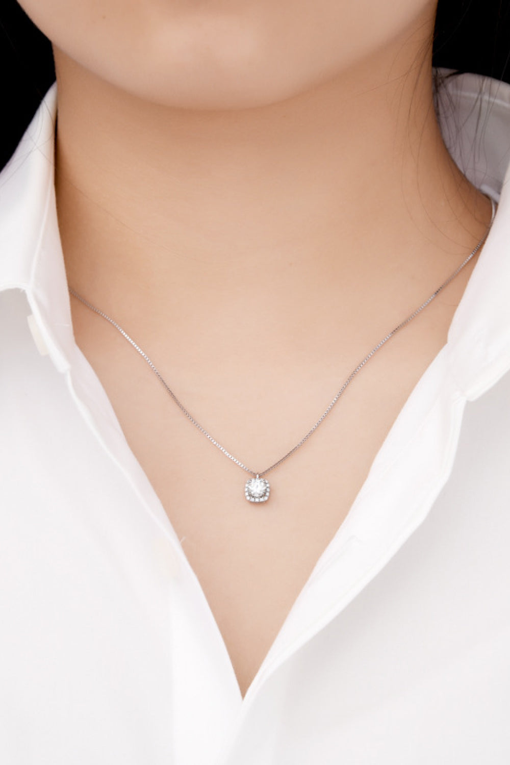 Silver halo diamond pendant necklace with a square center stone on a delicate chain.
