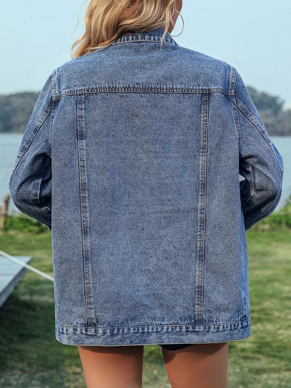 Blue denim trucker jacket with button-up front and chain fringe detail on back.