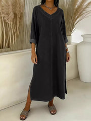 Dark blue midi dress with V-neck, long sleeves, and side slits.